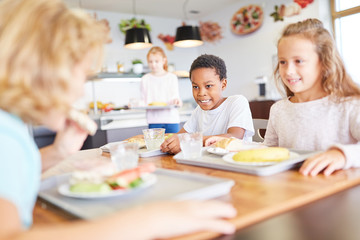 Glückliche Kinder essen in der Kantine