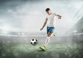 Outdoor kussens Soccer player on a football field in dynamic action at summer day © Andrii IURLOV