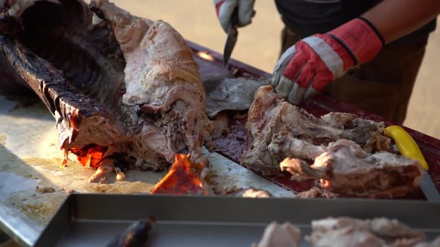 4K chef butcher is cutting the roasted suckling pig