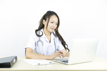 Smiling asian woman doctor working on computer laptop.