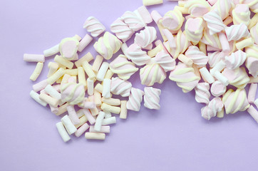 Colorful marshmallow laid out on violet paper background. pastel creative texture. minimal