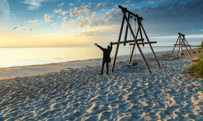 Happy man looking at sunrise, coastal landscape of the Baltic Sea, EC, Europe