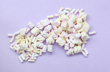 Colorful marshmallow laid out on violet paper background. pastel creative texture. minimal