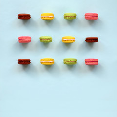 Dessert cake macaron or macaroon on trendy pastel blue background top view. Flat lay composition