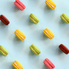 Dessert cake macaron or macaroon on trendy pastel blue background top view. Flat lay composition