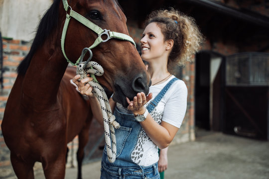 Fototapeta Young woman taking care of her beautiful horse.