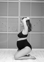 Beautiful pregnant woman is posing on camera. Pregnancy concept.