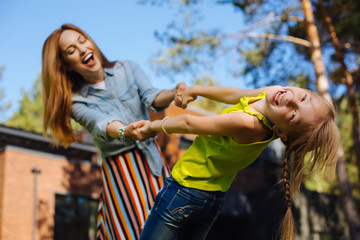 Great time. Content charming girl smiling and having fun with her mom