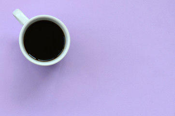 Small white coffee cup on texture background of fashion pastel violet color paper in minimal concept