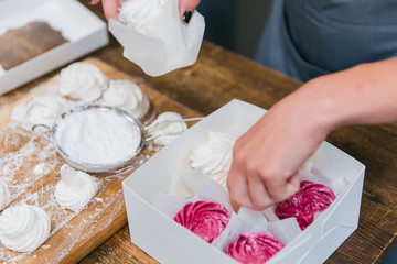 Girls prepare beautiful and tasty desserts on a wooden table and decorate with fruits