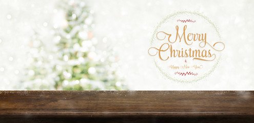 Merry Christmas and happy new year wreath with golden glitter texture over brown wood table top at blur bokeh christmas tree decor with string light background,Winter holiday greeting card