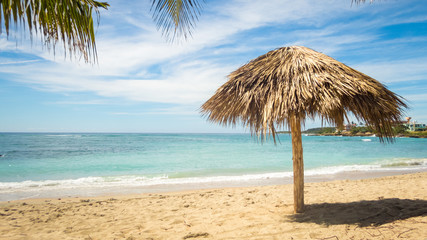 karibischer Traumstrand mit Sand und Sonnenschirm in Playa Rancho Luna