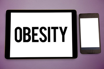 Writing note showing Obesity. Business photo showcasing Medical condition Excess of body fat accumulated Health problem Wide framed white smart screen tablet text messages communicate idea.