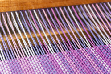 detail of fabric in comb loom with ultraviolet and lilac colors