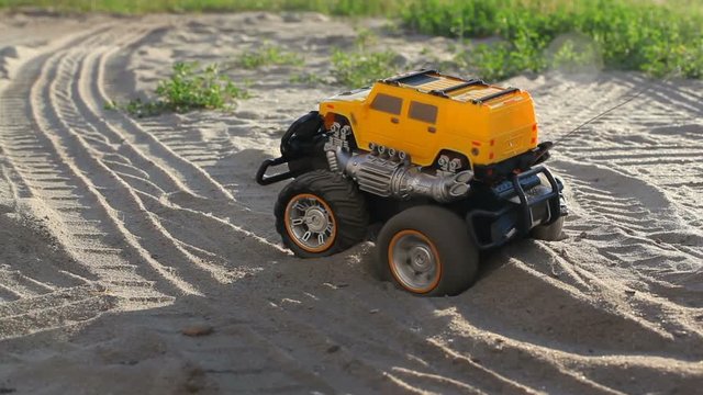 Radio-controlled car was stuck in the pit at the beach and blowing sand