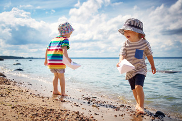 Babygirl and babyboy sitting on the beach