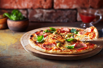 Thin crust pizza with ham, cheese and olive.  Freshly baked pizza (from wood-fired oven).  