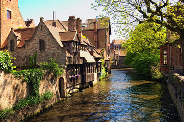 Fototapeta na wymiar Beautiful view of the canal and traditional houses in the old town of Bruges (dutch: Brugge), Belgium. Spring landscape photo