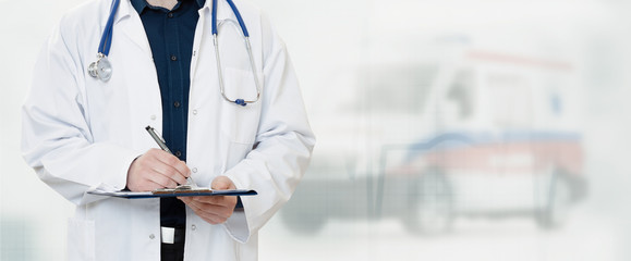 Doctor in hospital with ambulance in background © Proxima Studio