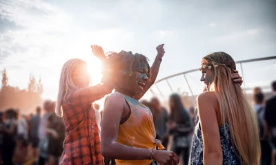 Gordijnen Multiethnic girls covered in colorful powder dancing and celebrating summer holi festival © leszekglasner