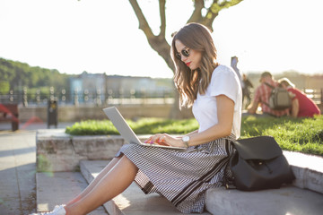 Girl with laptop sitting at the park