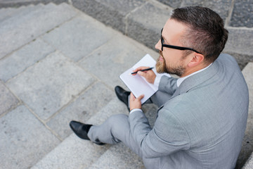 overhead view of businessman writing in planner
