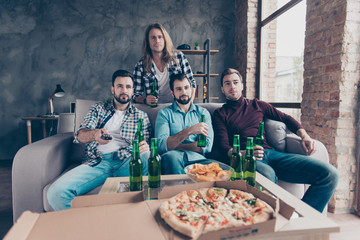 Four attractive stylish bearded guys with modern hairstyle in denim outfit sitting together in...