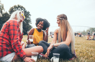 Group of friends drinking beer at summer music festival outdoor