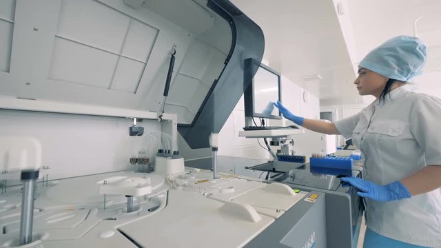 One nurse works with a blood testing machine.
