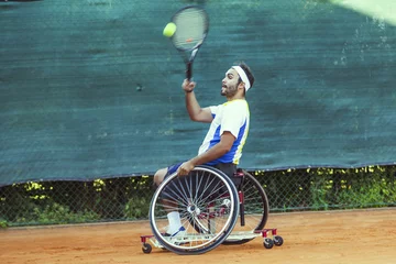 Foto op Canvas disabled tennis player hits the ball forehand © Marino Bocelli