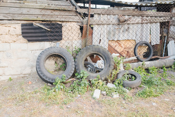 Old tire and breeding ground for mosquito. Remnants of broken pieces after the demolition of an old...