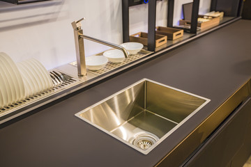 Kitchen faucet, modern kitchen in loft style, black table, gold luxury faucet kitchen