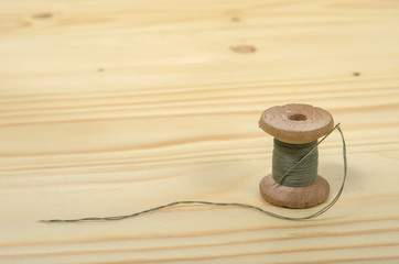 The old spool of thread with a needle.