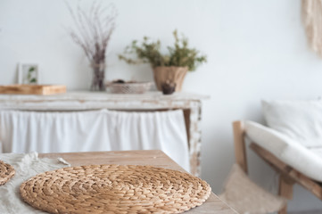 Fototapeta premium White textured kitchen in the style of shabby. A large textured table in the ecological style and Loft style. Rustic wicker napkins, light green tablecloth, diy.