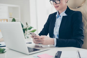 Apps media cellular concept. Cropped portrait of serious concentrated expert in shirt jacket typing sms holding smart phone in hands using 3G wi-fi internet sitting in modern workstation