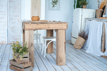 White textured kitchen in the style of shabby. A large textured table in the ecological style and Loft style. Rustic wicker napkins, light green tablecloth, diy.