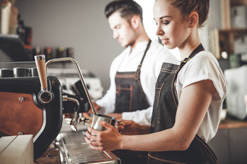 Successful cafe business, professional baristas team using coffee machine
