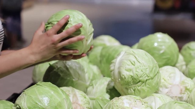 Female hands holding cabbage in the store