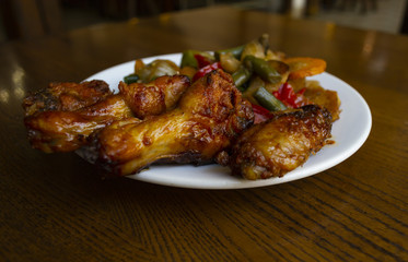 Spicy chicken wings with stewed vegetables.