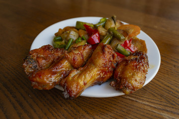 Spicy chicken wings with stewed vegetables.