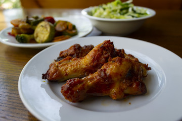 Spicy chicken wings with stewed vegetables.