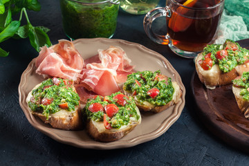 Bruschetta with fresh pesto, mozzarella and cherry tomatoes on a plate