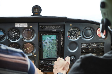 Closeup of a cockpit of cessna skyhawk 172 airplane with two pilots. - obrazy, fototapety, plakaty