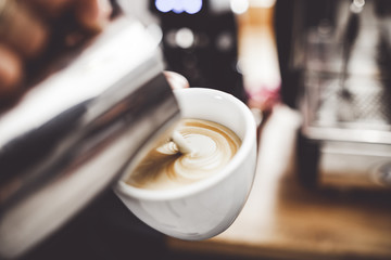Coffee latte art, barista pouring milk into cup - obrazy, fototapety, plakaty