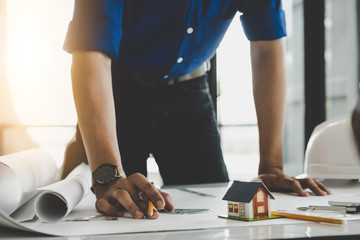 architect drawing on blueprint architectural, Young man working on his plane project at site construction work.
