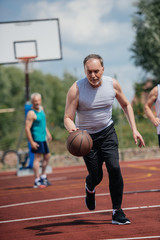 Obraz premium selective focus of old friends playing basketball on summer day