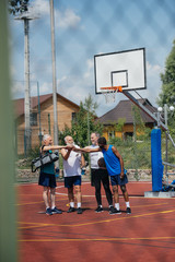 multiethnic elderly sportsmen with basketball ball on playground