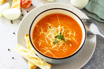 Puree soup tomato with croutons and cheese in a bowl on a light slate background. The concept of healthy eating. Diet menu. Copy space.