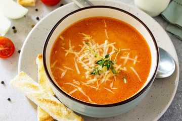 Puree soup tomato with croutons and cheese in a bowl on a light slate background. The concept of healthy eating. Diet menu.