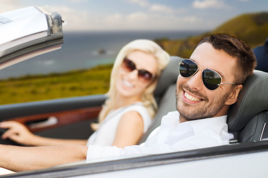 road trip, travel and people concept - happy couple driving in convertible car over big sur coast of california background